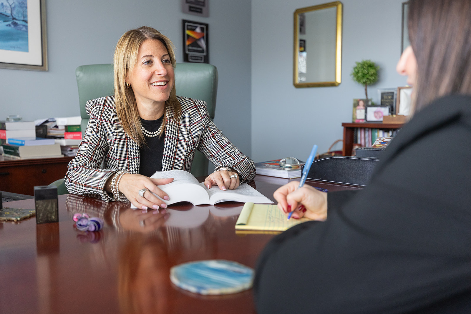 Sarinia M. Feinman at desk talking to another attorney - divorce arbitration -  Feinman & Childs Family Law