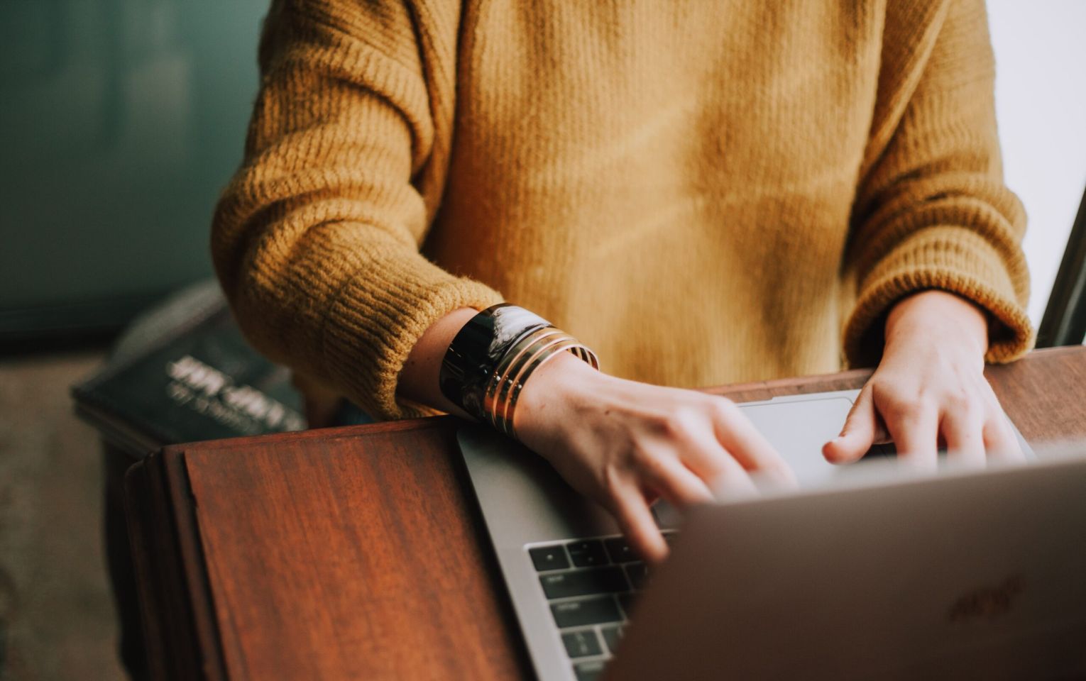 woman in sweater at laptop | parenting coordination | Feinman & Childs Family Law